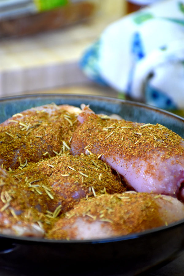 chicken thighs in a bowl covered in the spice rub