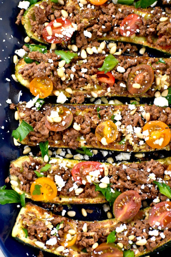 Close up of Mediterranean zucchini boats on a beautiful blue platter.