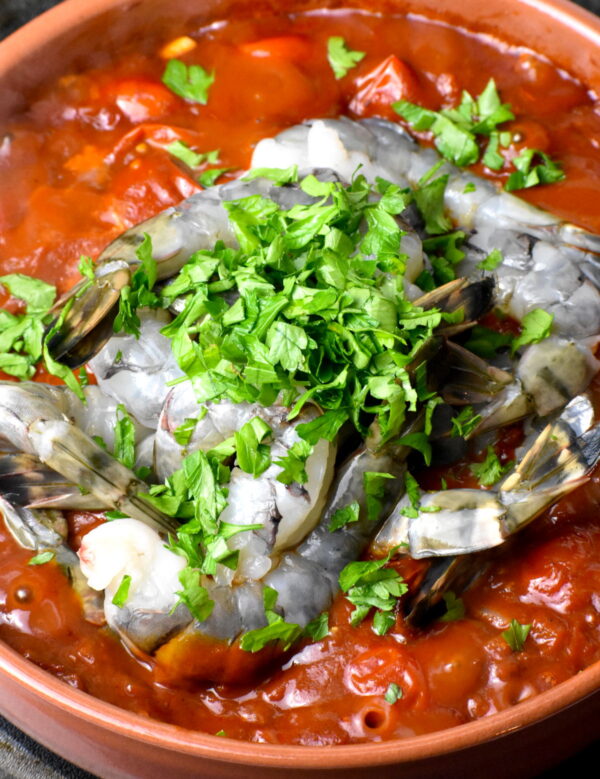 adding shrimp and parsley into the dish.